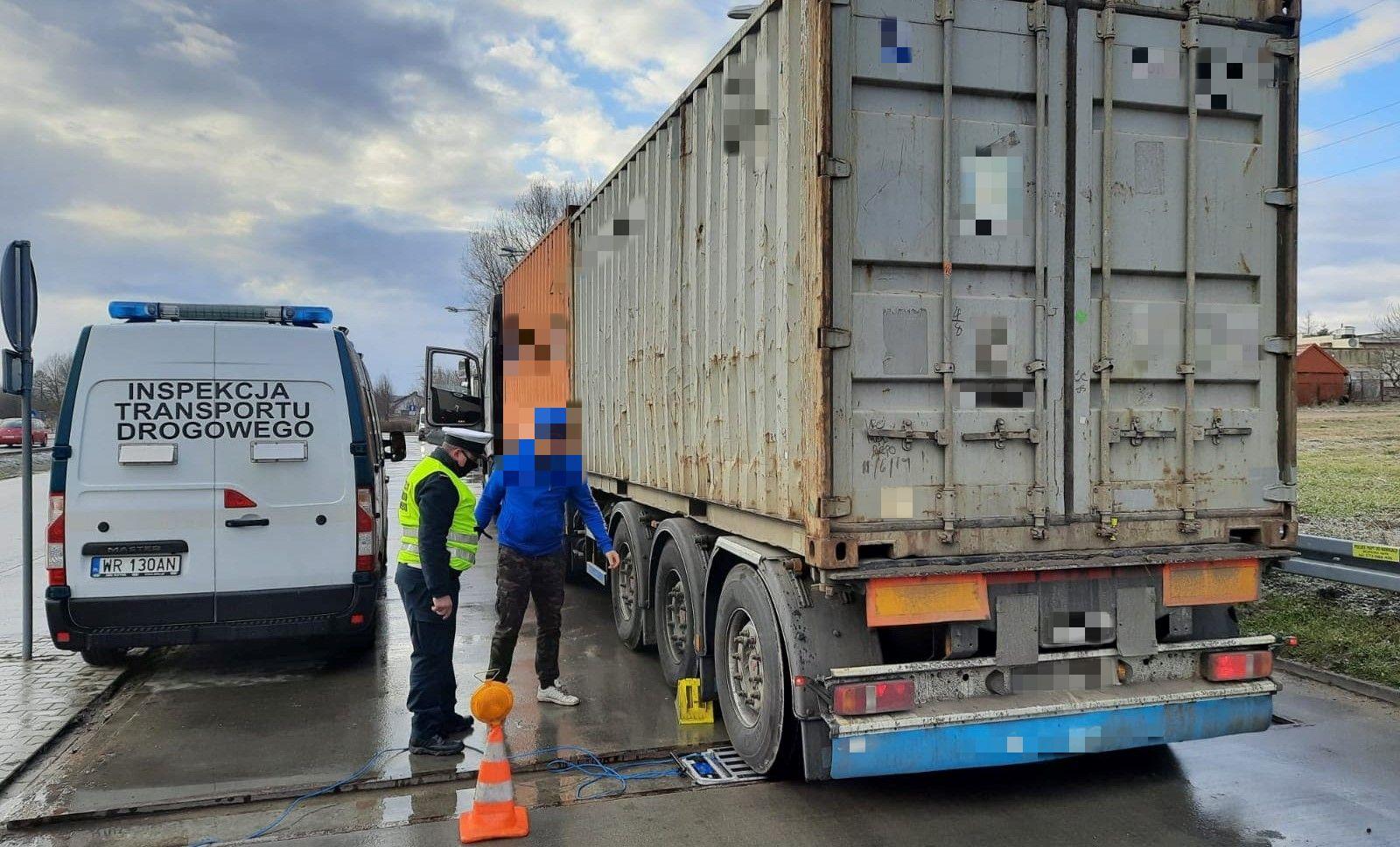 Inspektor waży ciężarówkę przewożącą kontenery z ładunkiem.