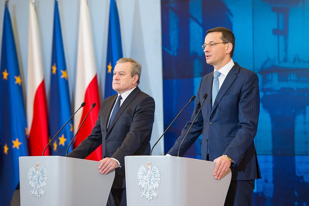 Premier Mateusz Morawiecki i wicepremier Piotr Gliński przy mównicach.