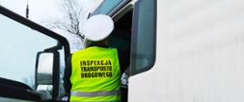 Czynności kontrolne przeprowadzane przez jednego z inspektorów z WITD w Bydgoszczy. Na zdjęciu inspektor ITD zagląda do kabiny ciężarówki.