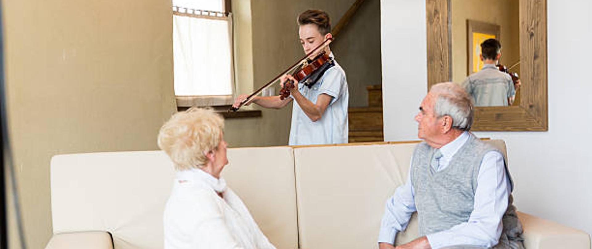Young boy playing violin to his grandparents.