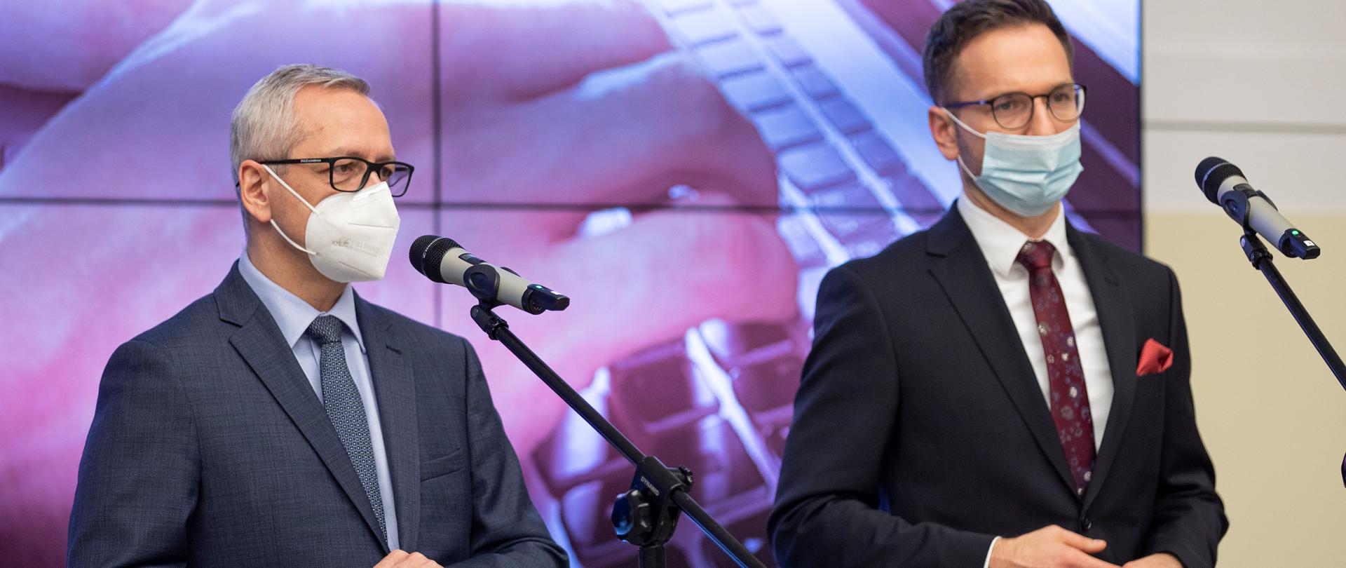 wiceministrowie Marek Zagórski i Waldemar Buda stoją przed mikrofonami