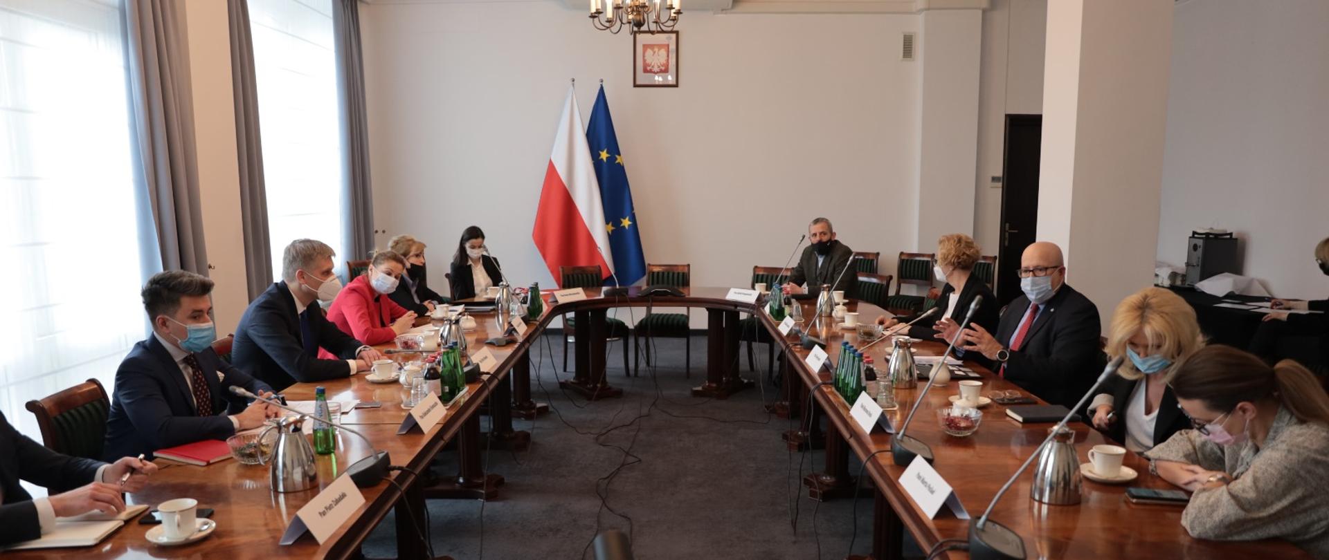 na zdjęciu spotkanie ministra Piotra Nowaka z Amerykańską Izbą Gospodarczą, Minister siedzi za owalnym stołem wraz z pozostałymi uczestnikami spotkania 