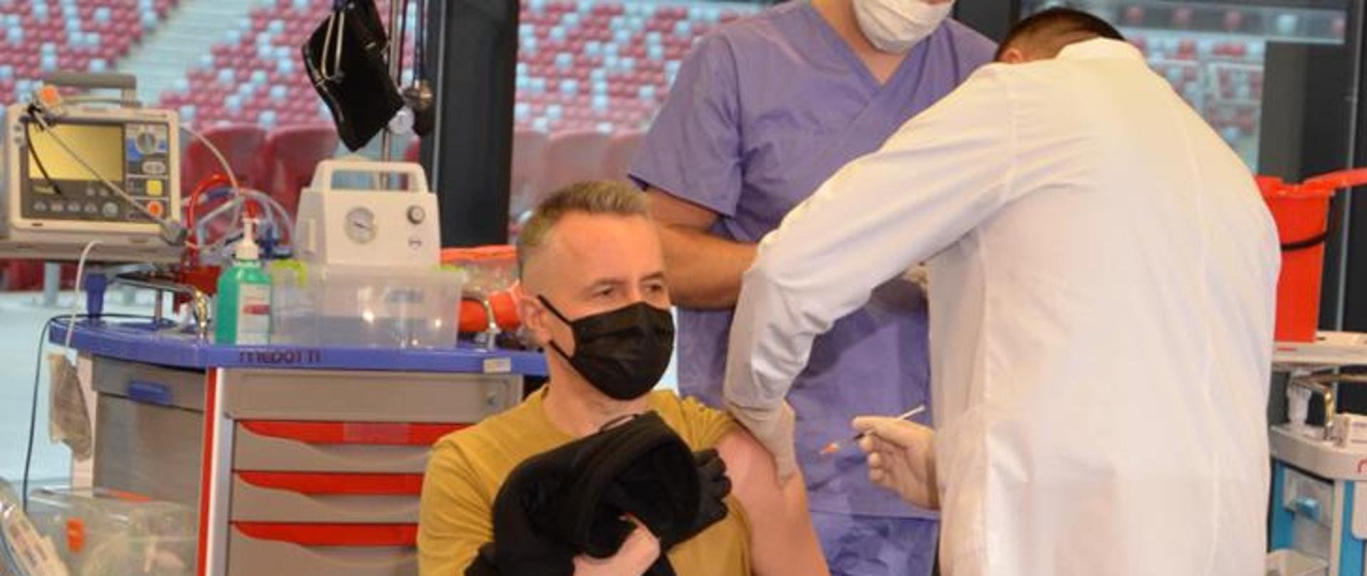 Na zdjęciu widać Komendanta Głównego Państwowej Straży Pożarnej nadbrygadiera Andrzeja Bartkowiaka przyjmującego szczepionkę