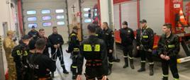Grupa strażaków na garażu JRG w trakcie szkolenia praktycznego