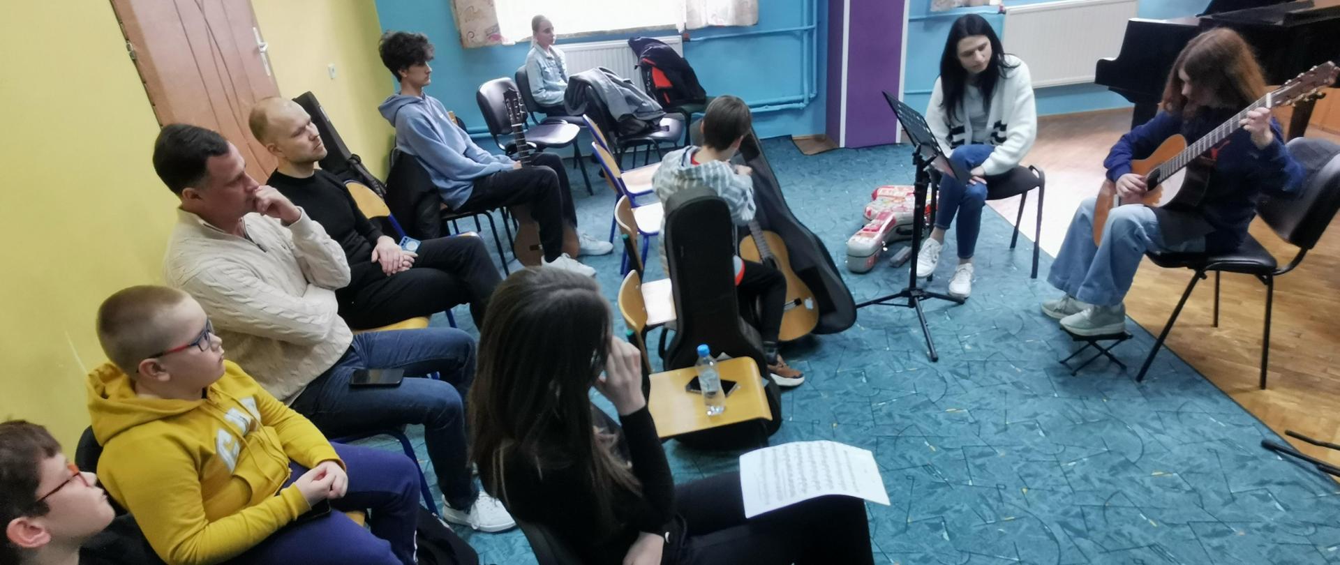 Zdjęcie przedstawiające wszystkich uczestników konsultacji klas gitary, które odbyły się w małej auli szkoły - 18.04.2024 r.