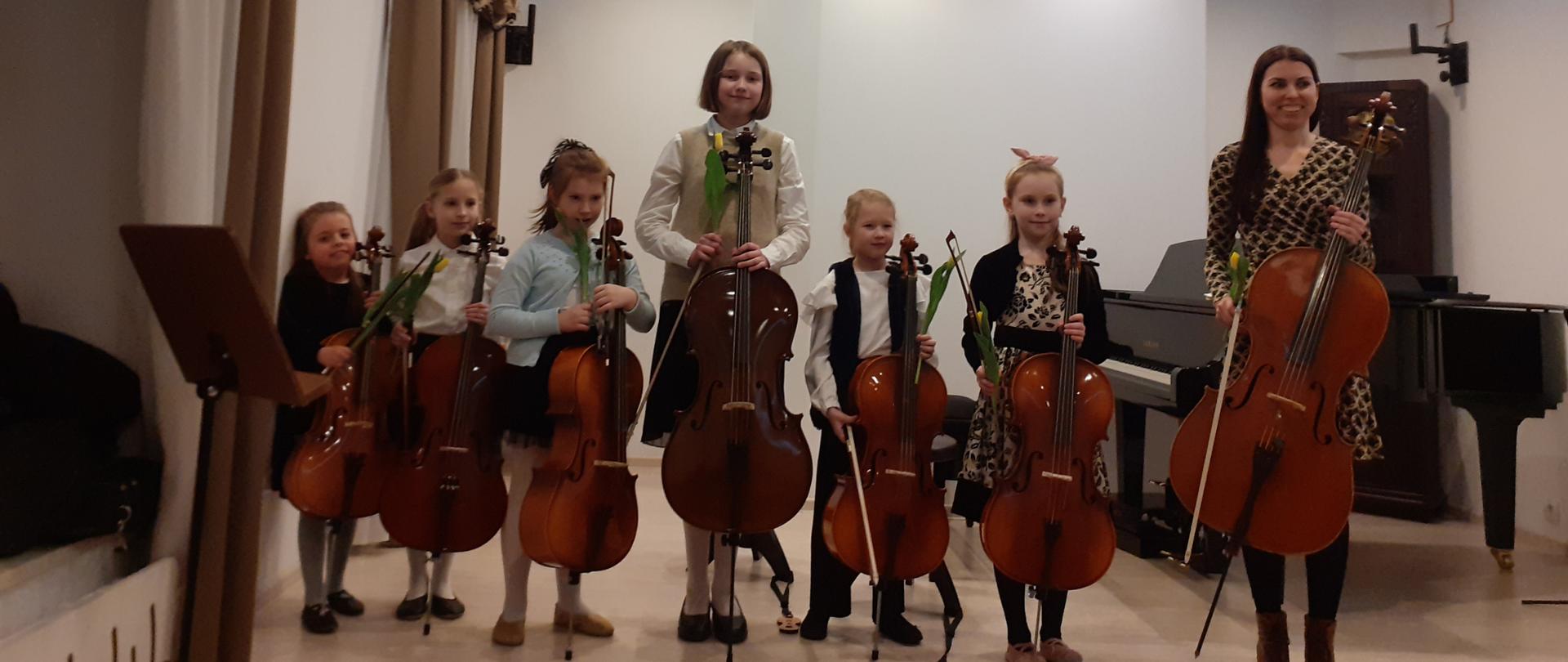 Grafika przedstawia szóstkę dzieci z instrumentami. 