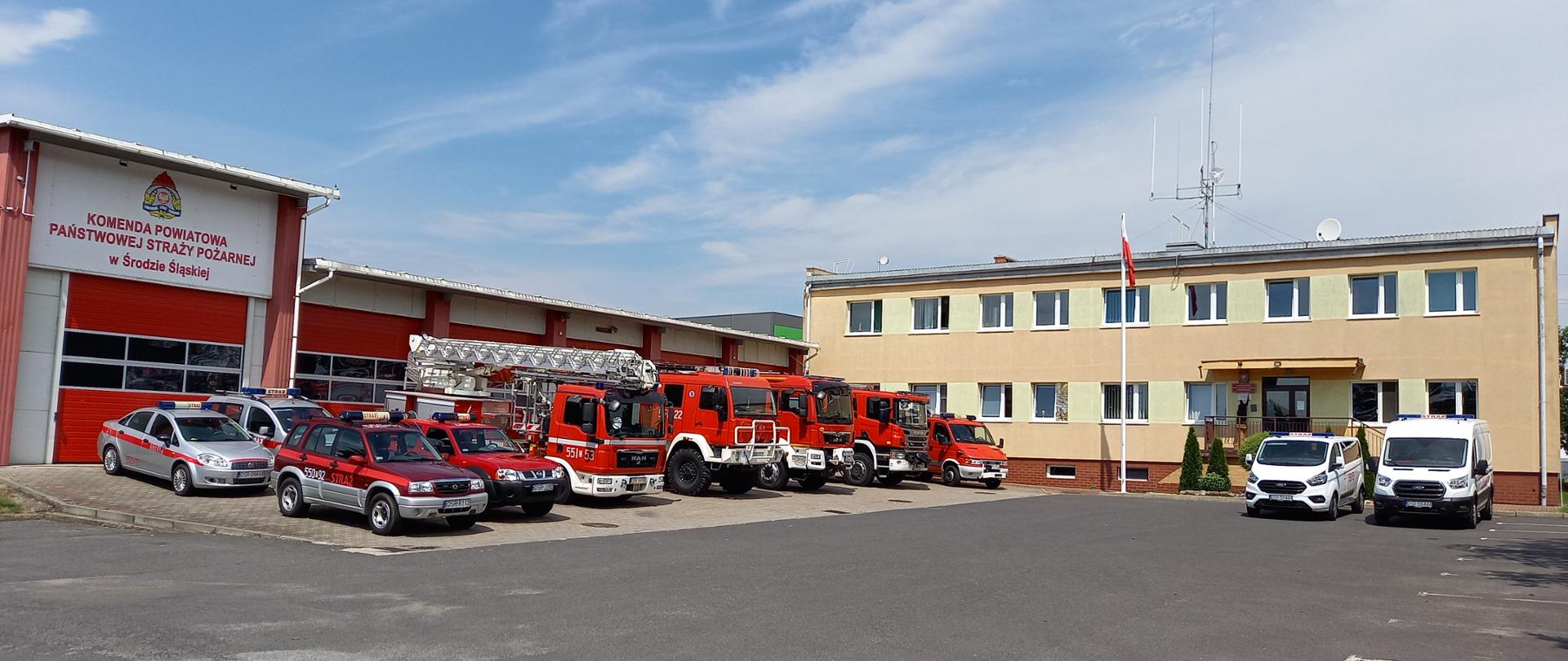 Widok placu przed garażami jednostki ratowniczo - gaśniczej oraz samochodów pożarniczych będących na wyposażeniu straży pożarnej w Środzie Śląskiej