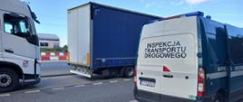 Tył i prawy bok oznakowanego furgonu wielkopolskiej Inspekcji Transportu Drogowego. Obok stoją dwie zatrzymane do kontroli ciężarówki.