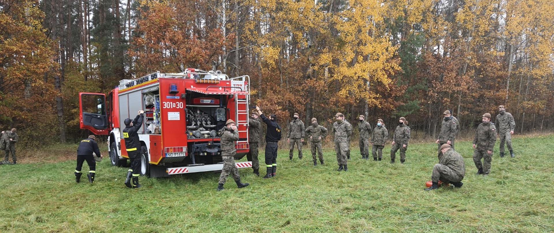 Zdjęcie przedstawia wspólne ćwiczenia Państwowej Straży Pożarnej oraz Wojsk Obrony Terytorialnej