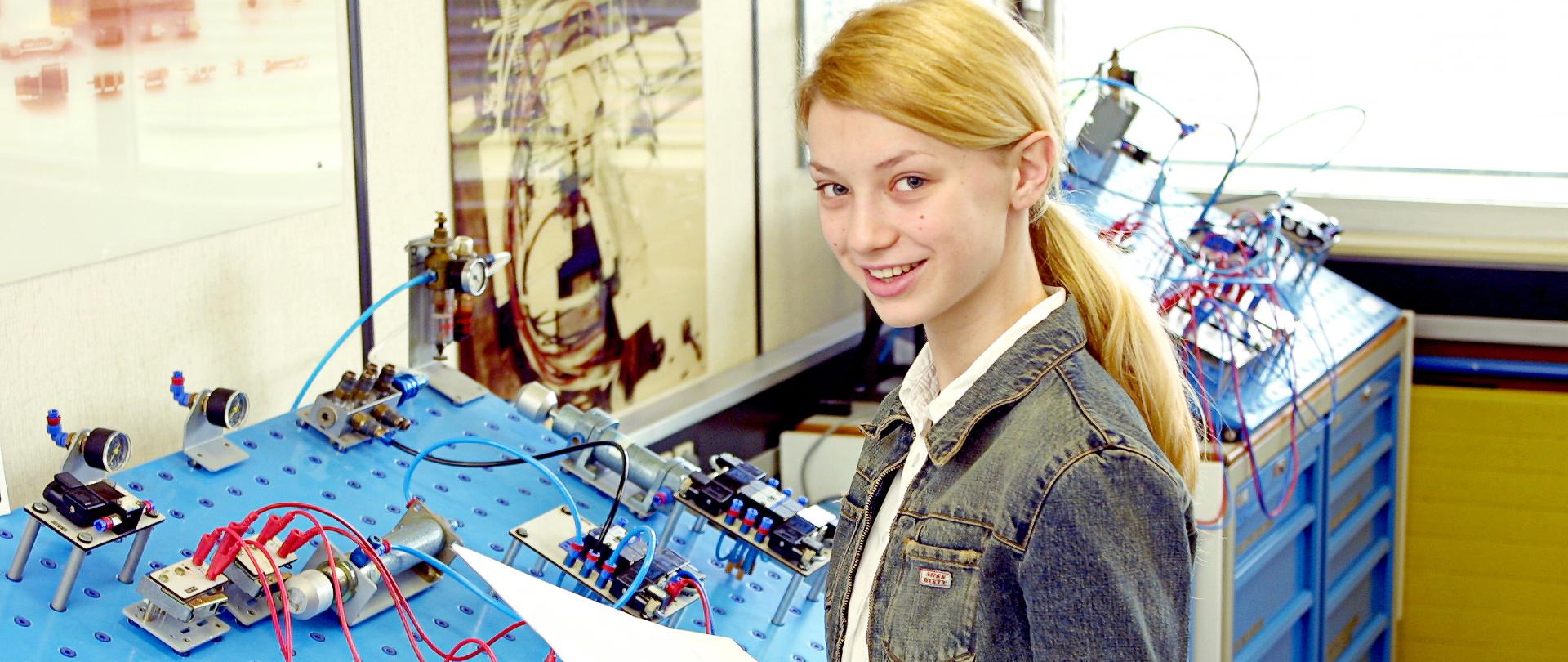 Młoda dziewczyna łączy obwód elektryczny na płycie prototypowej.