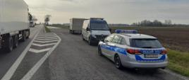 Oznakowany radiowóz Policji, oznakowany furgon mazowieckiej Inspekcji Transportu Drogowego i zatrzymany do kontroli samochód dostawczy stoją w zatoce dla służb kontrolnych przy krajowej „dziesiątce” w okolicach Sierpca. Obok zatoki przejeżdżają samochody ciężarowe z naczepami.