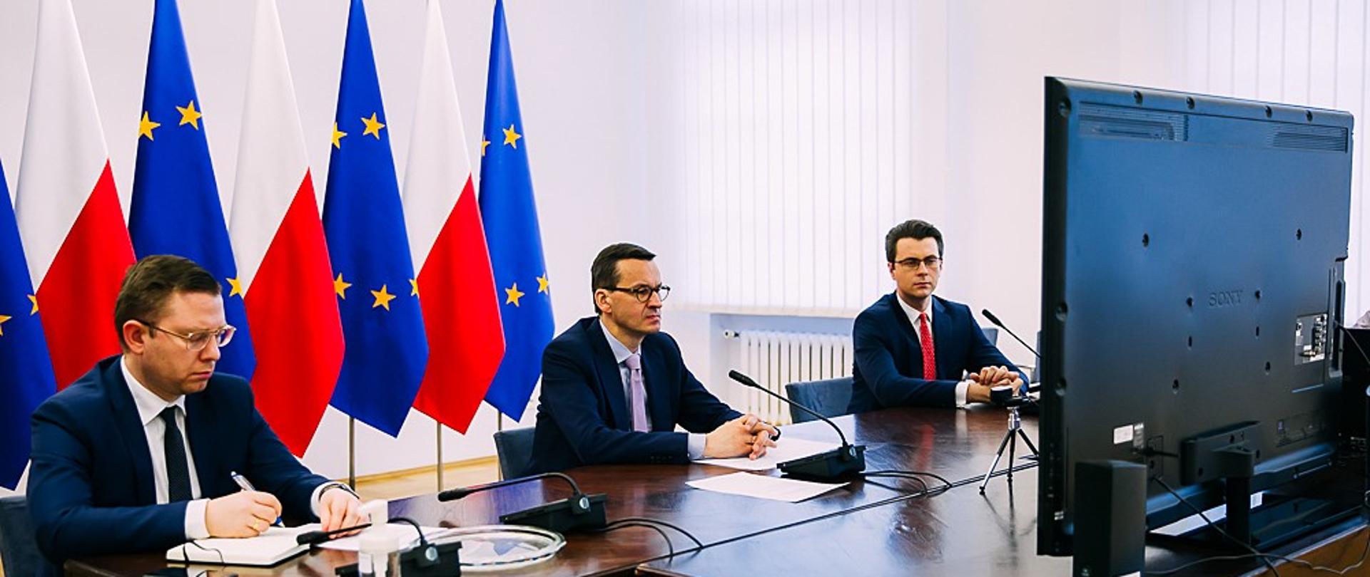 Minister Krzysztof Kubów, premier Mateusz Morawiecki i rzecznik rządu Piotr Muller przed monitorem.