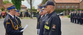 Komendant Wojewódzki oraz Komendant Miejski stoją na przeciwko czterech oficerów i wręczają im awanse na wyższe stopnie służbowe. 