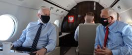 Wicepremier Jarosław Gowin oraz wiceminister Grzegorz Piechowiak rozmawiają na pokładzie samolotu rządowego.