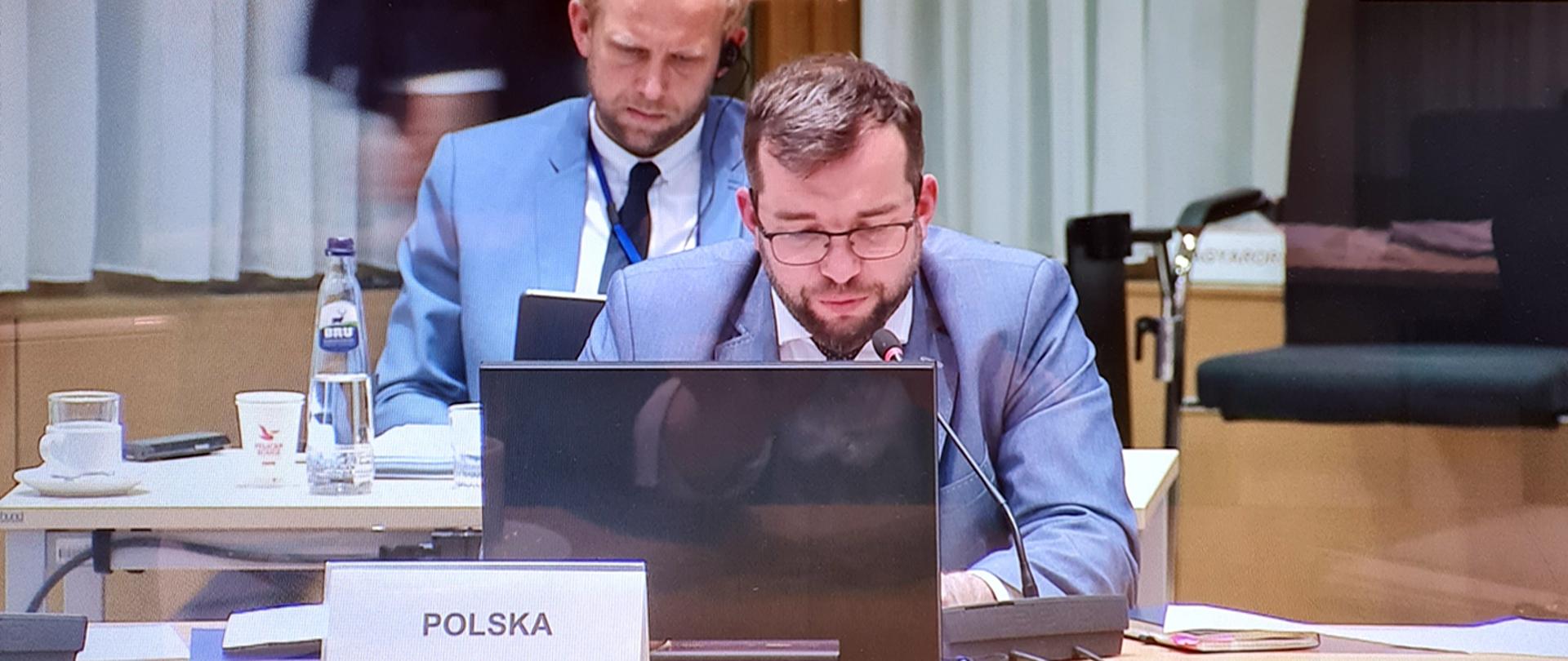 Minister Grzegorz Puda siedzący przy laptopie podczas obrad