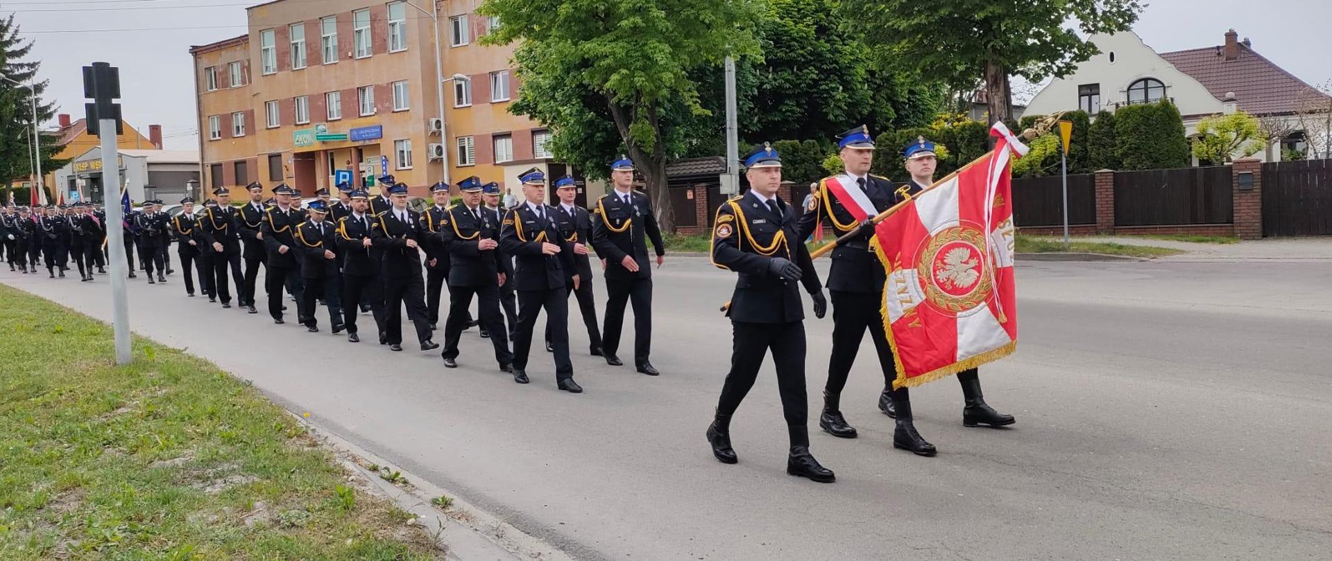 Zdjęcie przedstawia defiladę strażacką na czele z pocztem sztandarowym KP PSP w Jędrzejowie.