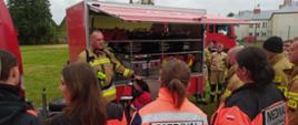 Widoczne służby ratownicze obserwujące pokaz mobilnej bazy sprzętu ratownictwa medycznego z KW PSP Białystok