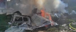 Zdjęcie przedstawia pożar garażu. Na zdjęciu widać ogień i strażaków walczących z żywiołem.
