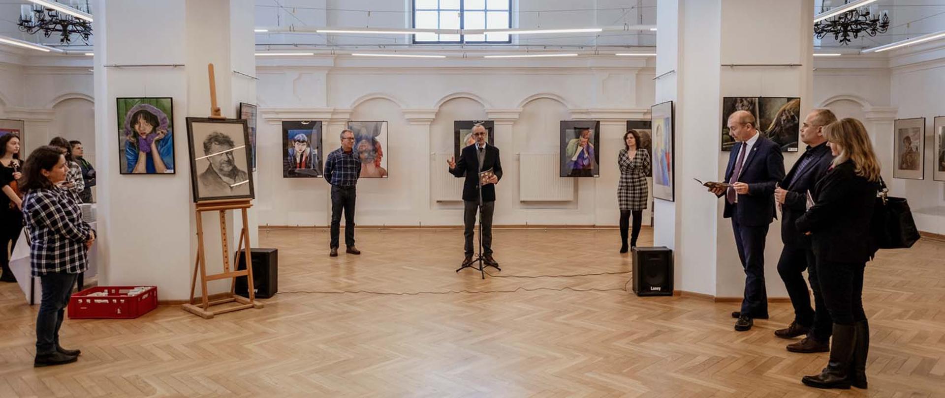 Zdjęcie przedstawia grupę osób które, znajdują się w sali wystawowej PLSP w Jarosławiu. Uroczystość dotyczy otwarcia ogólnopolskiej wystawy pasteli.