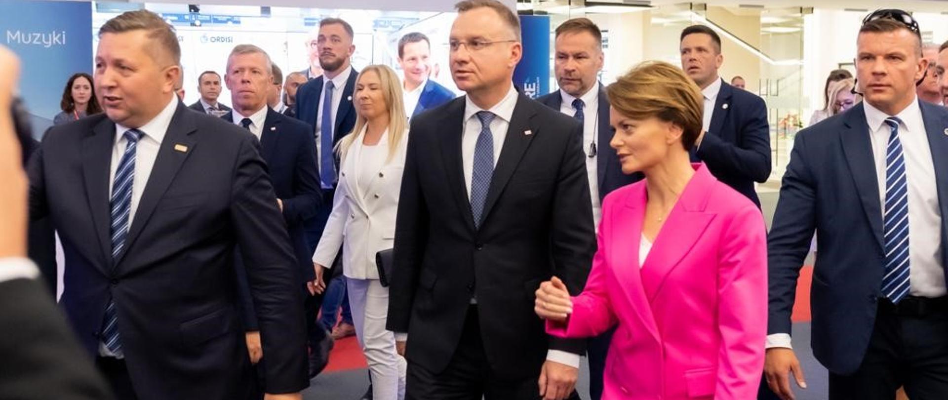 Wiceminister Jadwiga Emilewicz idzie obok prezydenta RP Andrzeja Dudy w tłumie osób. 