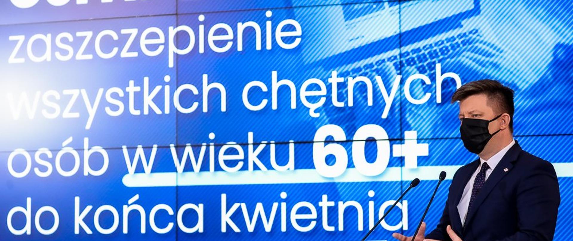 Na zdjęciu min. M. Dworczyk, w tle prezentacja z napisem: Cel NPS - zaszczepienie wszystkich chętnych osób w wieku 60+ do końca kwietnia