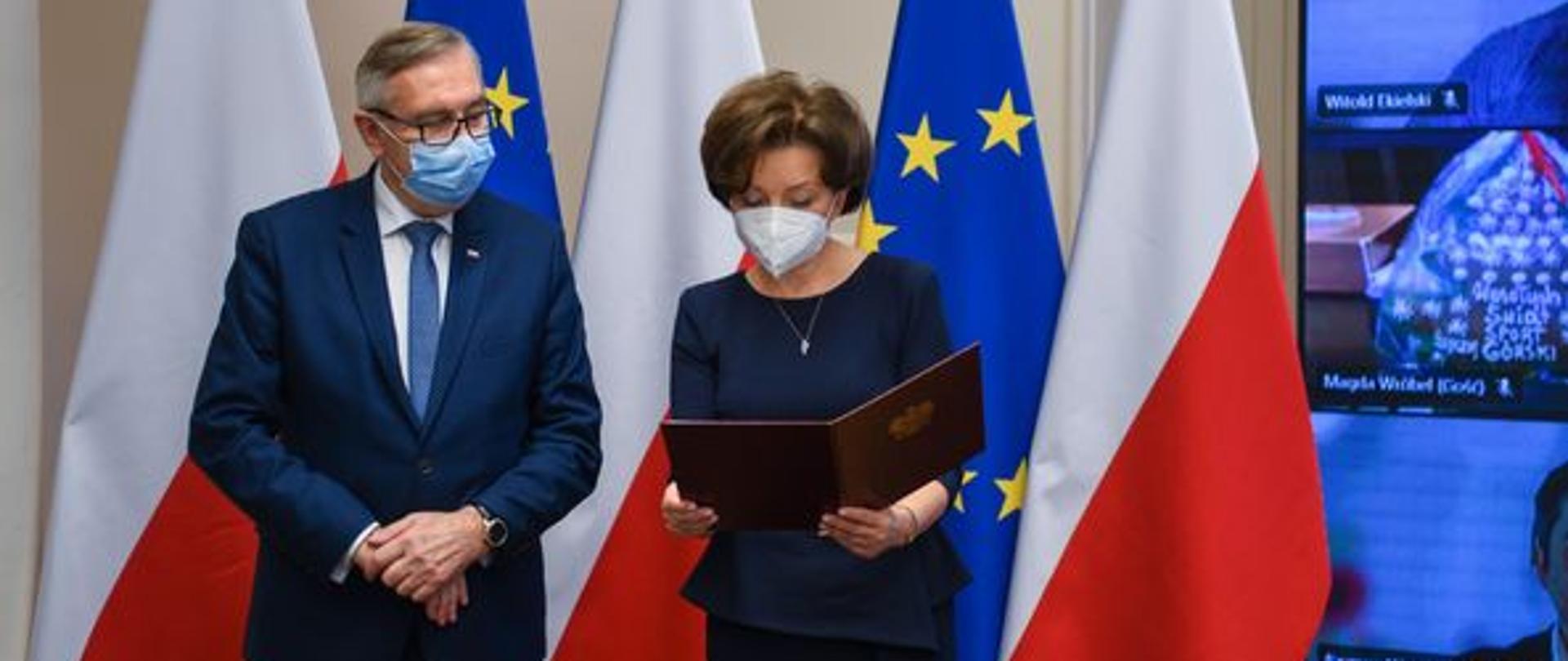 Na pierwszym planie stoją minister Maląg i wiceminister Szwed. W tle flagi Polski i Unii Europejskiej