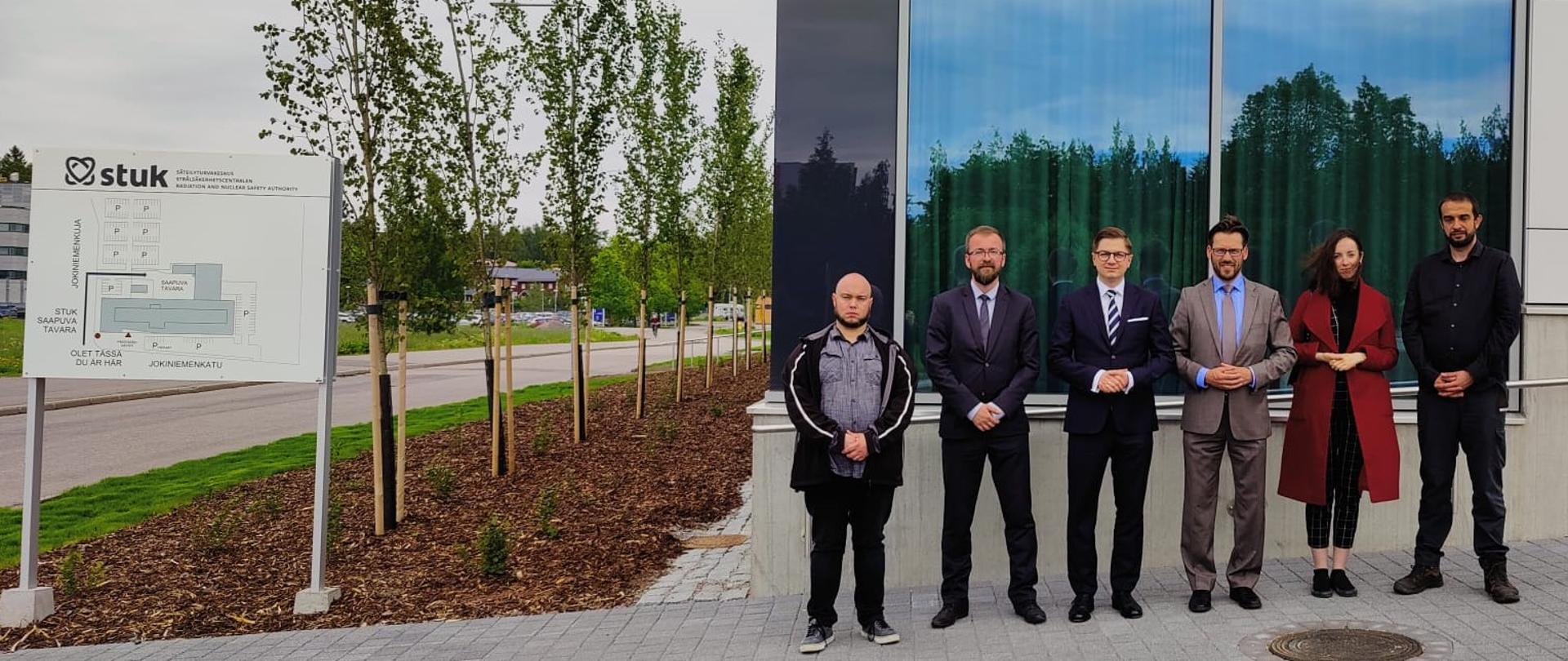 Prezes PAA dr Łukasz Młynarkiewicz oraz pozostali członkowie delegacji PAA stoją z władzami fińskiego urzędu dozoru jądrowego (STUK) przed jego siedzibą w Helsinkach.