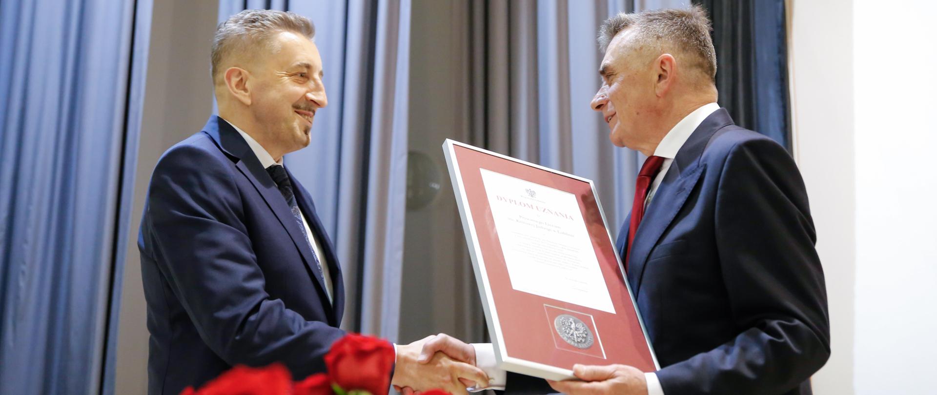 Wojewoda lubelski wręcza dyplom uznania dyrektorowi szkoły 
