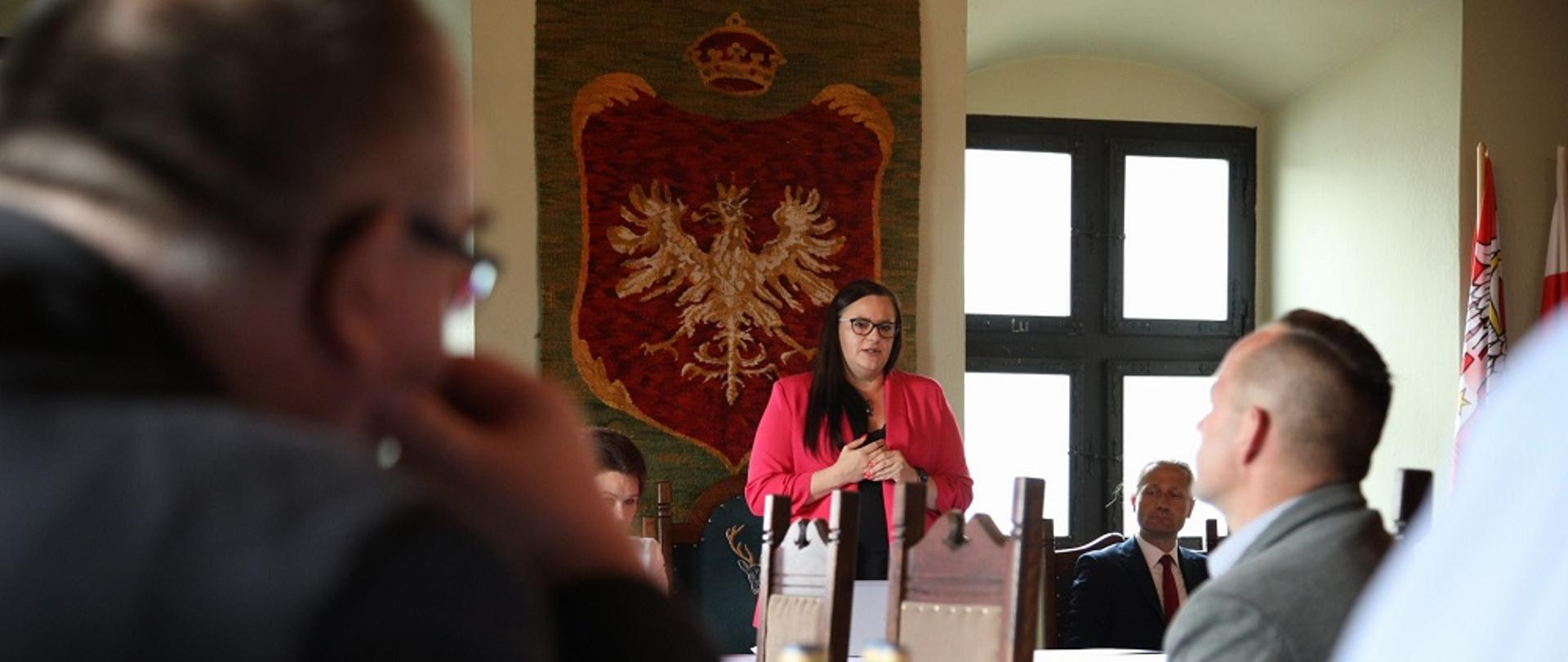 Minister Małgorzata Jarosińska-Jedynak przemawia na spotkaniu z samorządowcami i przedsiębiorcami w sali urzędu