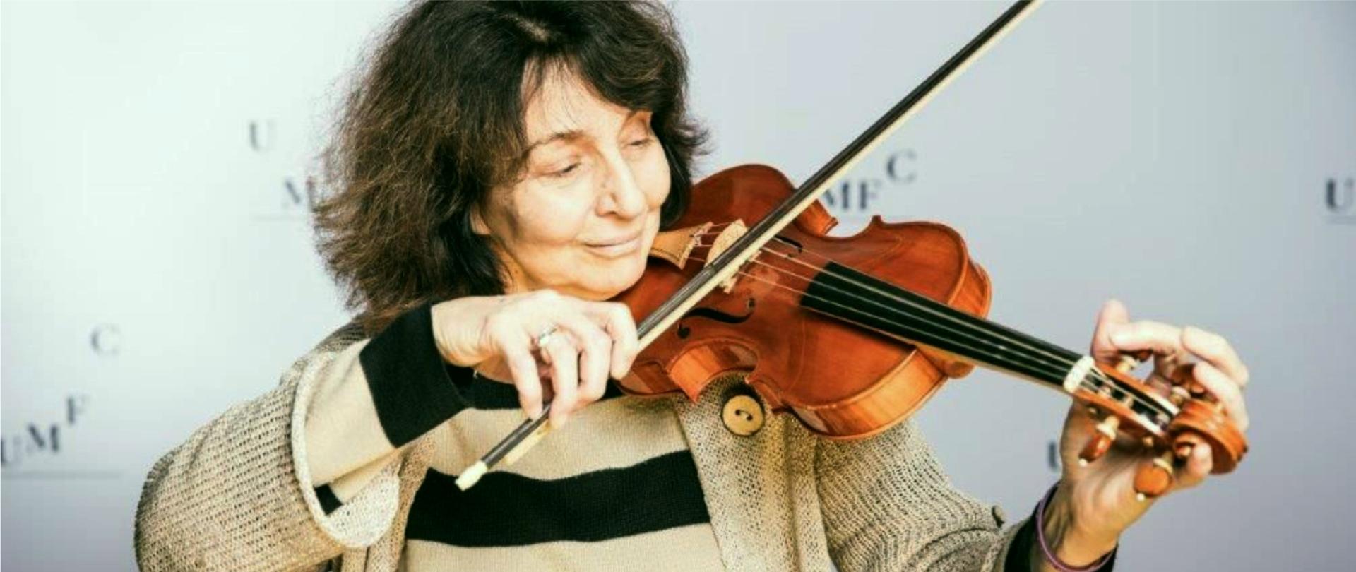 Zdjęcie przedstawia Agatę Sapiechę strojącą skrzypce barokowe