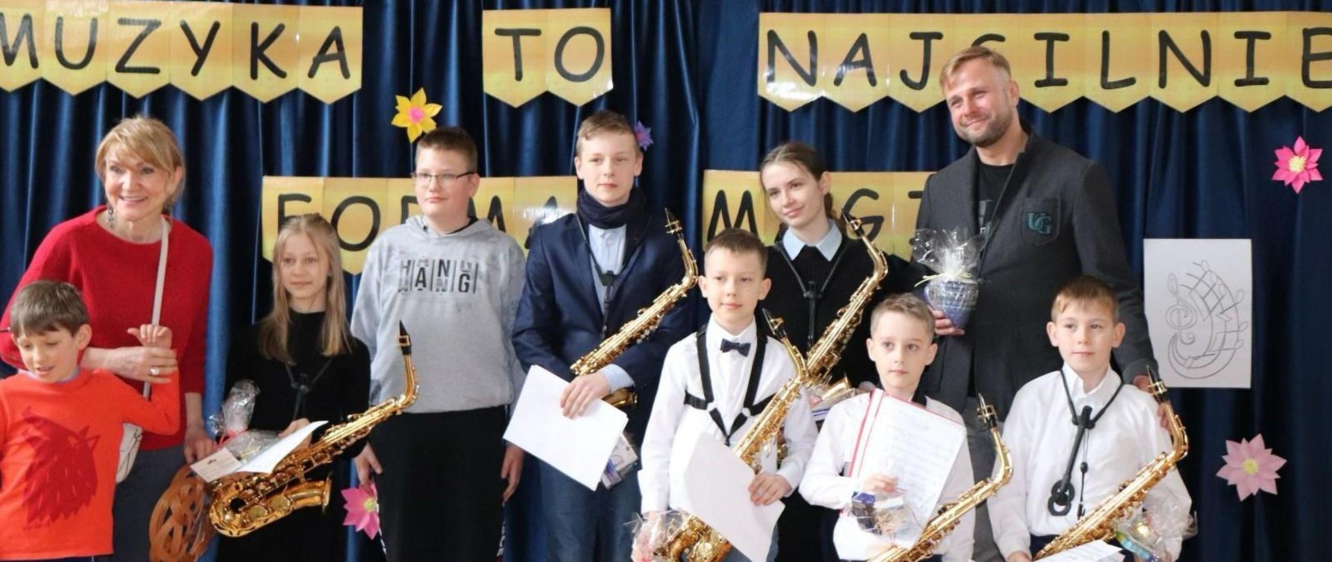 Zdjęcie przedstawiające wykonawców i uczestników koncertu saksofonowego, który odbył się w Powiatowym Zespole Szkół i Placówek Specjalnych w Bolesławcu w dniu 22.04.2024 r.