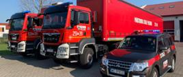3 samochody PSP , dwa ciężarowe i jeden SUV ustawione na placu przed wyjazdem z pomocą humanitarną do Niemiec