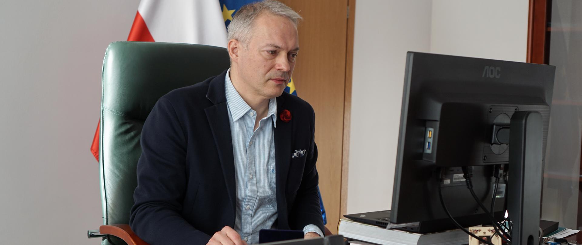 W gabinecie przy biurku z monitorem siedzi wiceminister Jacek Żalek