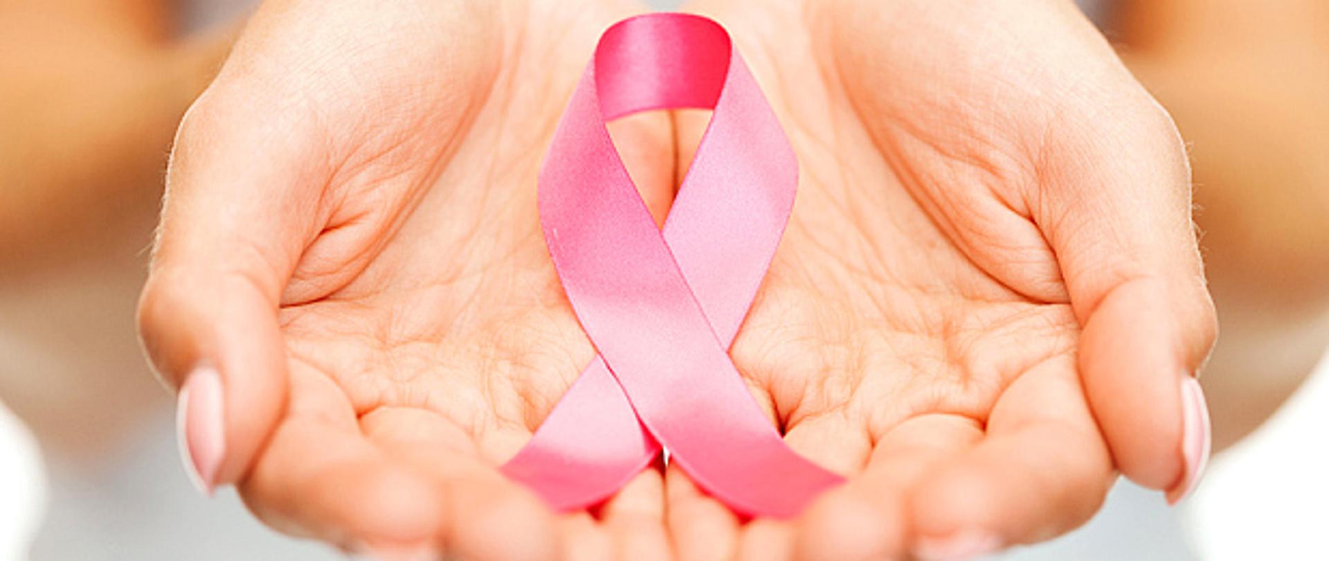różowa wstążka, symbol walki z rakiem w dłoniach kobiety