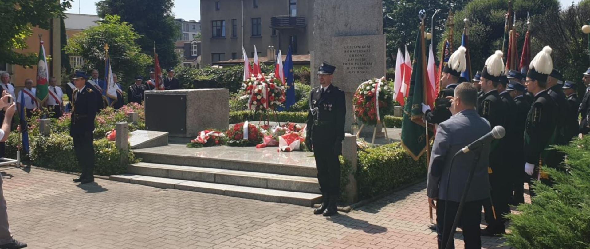 Na zdjęciu widać pomnik uczestników bohaterskiej obrony rafinerii w Czechowicach-Dziedzicach. Pod pomnikiem wieńce, obok warta honorowa dwóch strażaków PSP i OSP