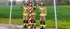 trzech umundurowanych strażaków podczas wciągania flagi na maszt