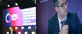 Wiceminister rozwoju i technologii Marek Niedużak z mikrofonem w ręku podczas obrad EFNI'21 w Sopocie, po jego prawej stronie telebim przedstawiający przemawiającego wiceministra M.Niedużaka