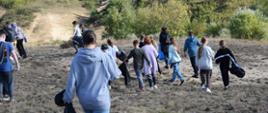 Grupa kilkanaściorga dzieci ze szkoły podstawowej wraz z opiekunami i przedstawicielami RDOŚ zbierają nielegalnie pozostawione odpady na terenie rezerwatu przyrody Gorzowskie Murawy