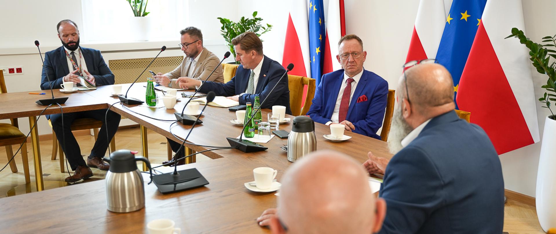 Minister Robert Telus oraz wiceminister Rafał Romanowski siedzący za stołem prezydialnym