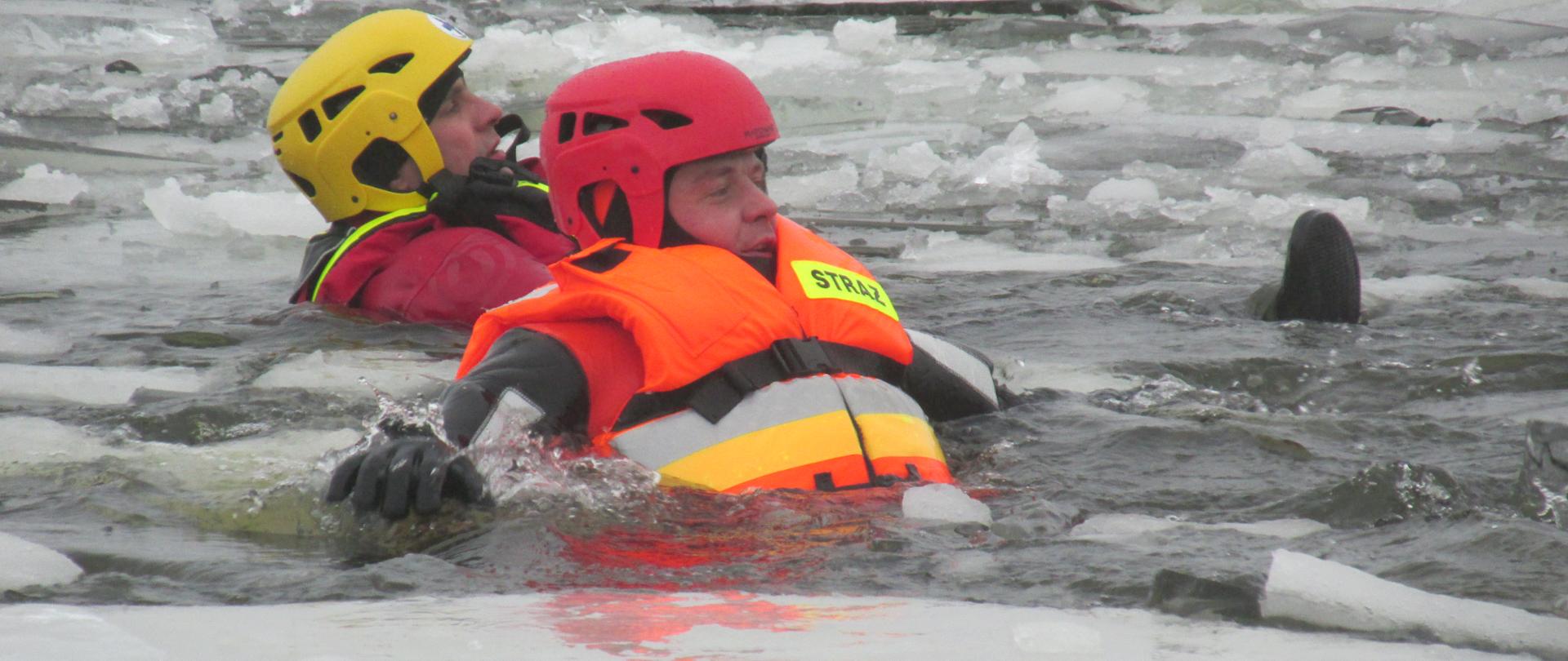 Zdjęcie przedstawia dwóch ratowników podczas ćwiczeń z ratownictwa lodowego