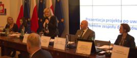 Zdjęcie przedstawia Beatę Kucharską-Mazurek, która przemawia podczas spotkania zespołu doradców ds. etyki w służbie cywilnej w KPRM.