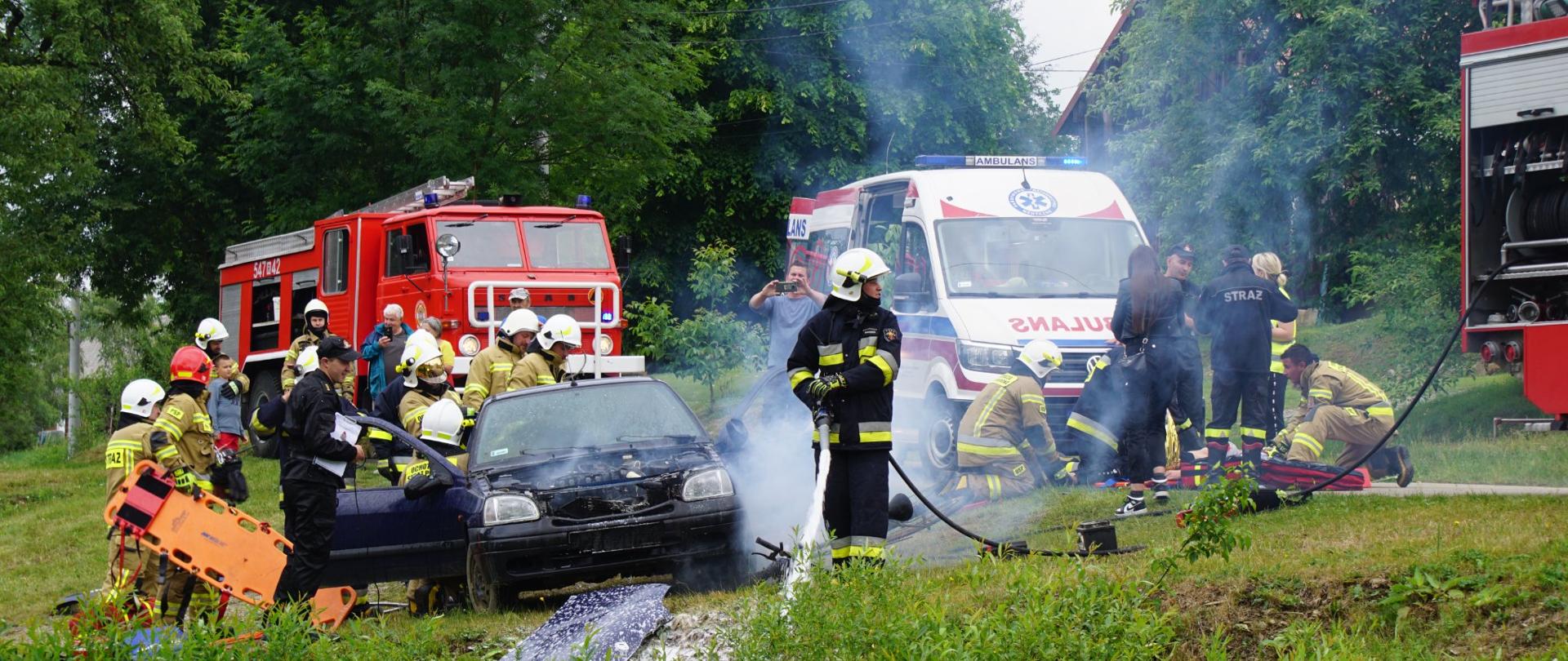 Zdjęcie przedstawia jeden z epizodów podczas ćwiczeń. Działania strażaków przy wypadku drogowym - dzialania gaśnicze, ratownicze oraz medyczne. 
