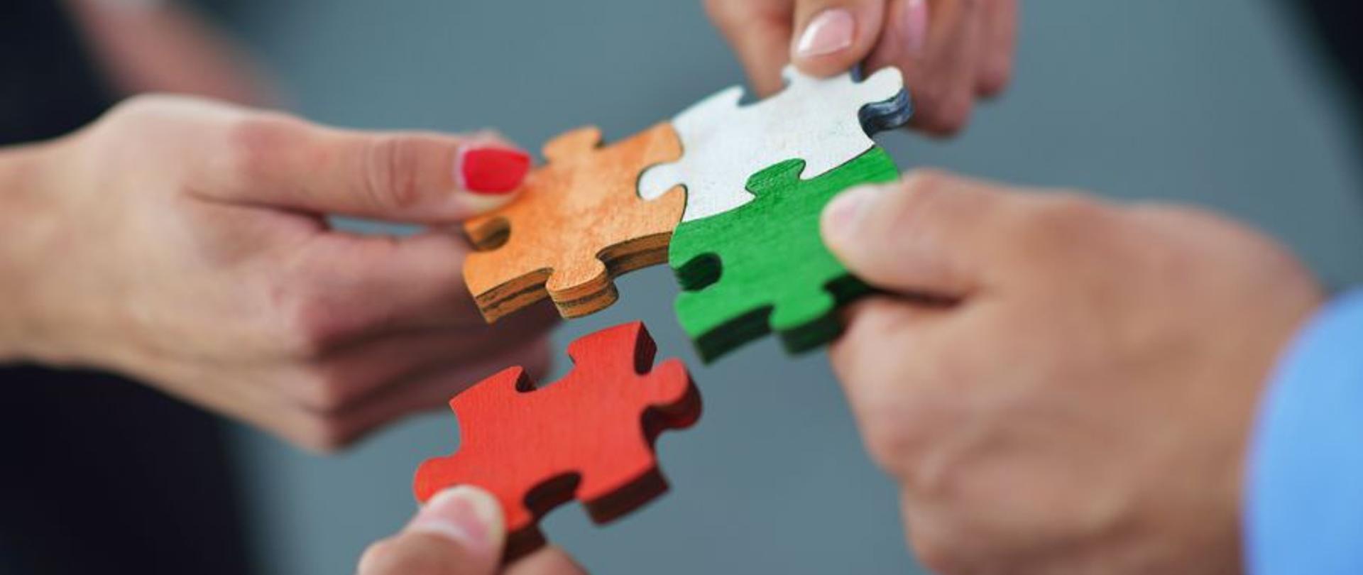 Partner poszukiwany, grupa ludzi składa puzzle jako symbol wsparcia