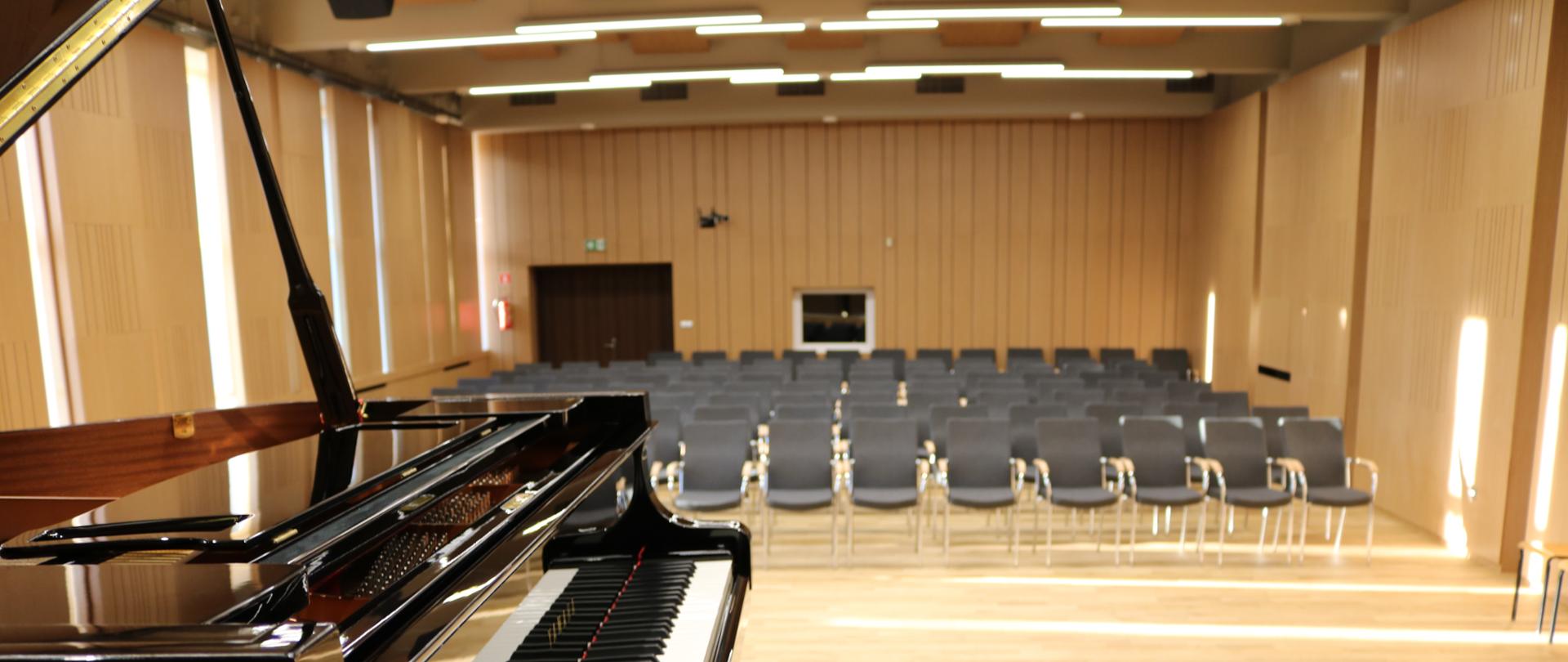 Zdjęcie przedstawia salę koncertową wraz ze sceną. Ujęcie skierowane jest od strony fortepianu w głąb sali.