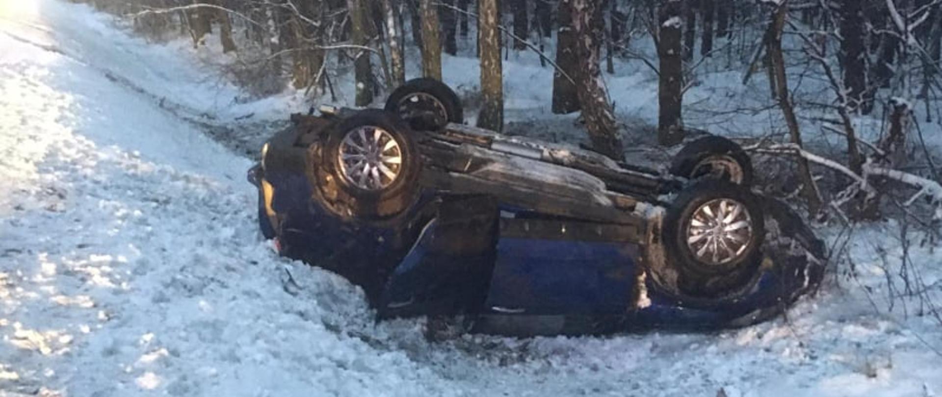 Zdjęcie przedstawia uszkodzony samochód osobowy marki Honda CRV znajdujacy sie na poboczu drogi. 