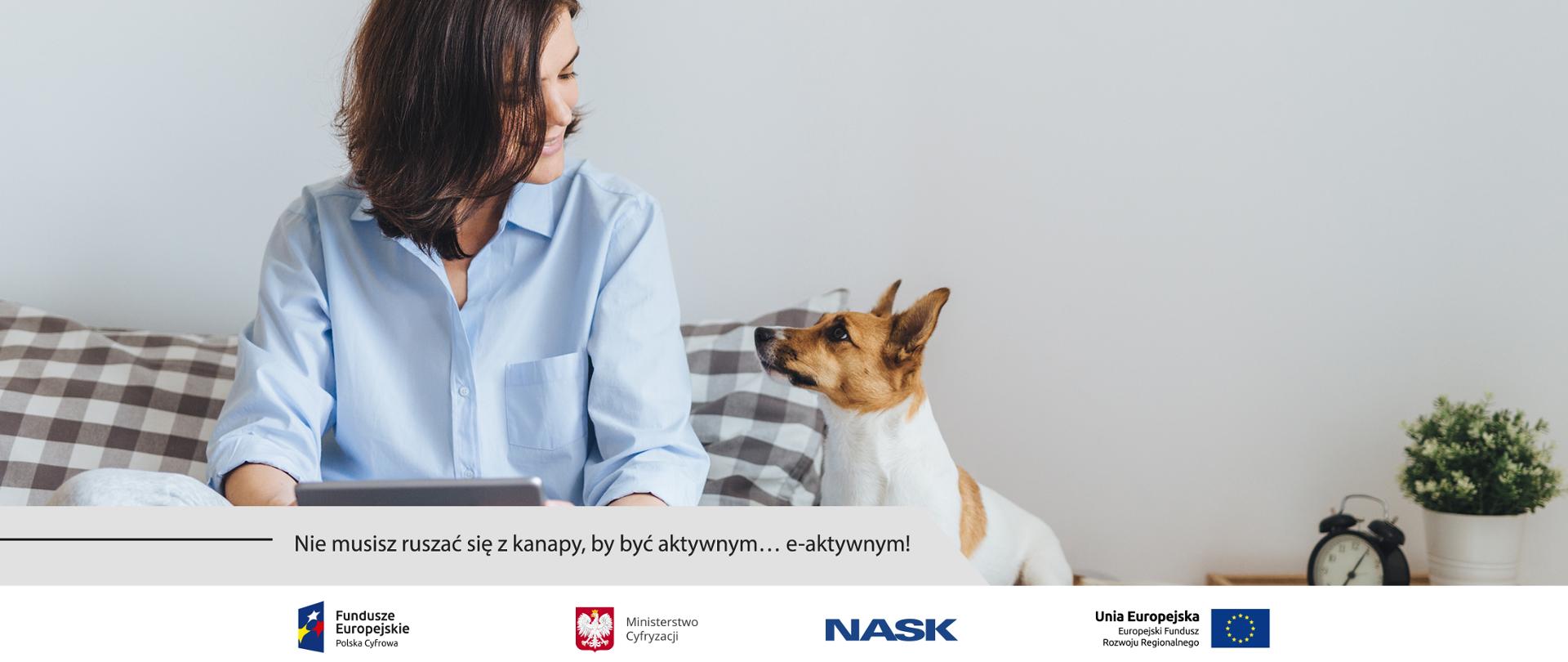 Kobieta siedząca po turecku na łóżku z tabletem w rękach. Patrzy na siedzącego obok, wpatrzonego w nią psa rasy Jack Russel terrier.