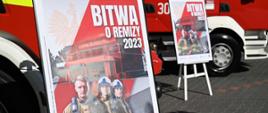 Dwa plakaty promocyjne akcji Bitwa o remizy 2023 na tle dwóch samochodów pożarniczych.