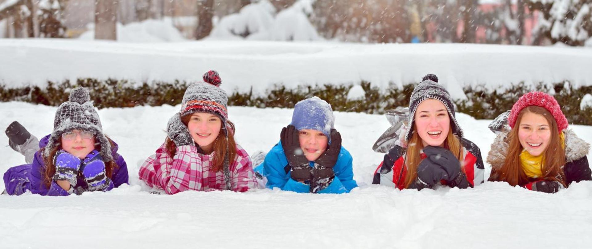 Zdjęcie przedstawia 5 dzieci bawiących się na śniegu