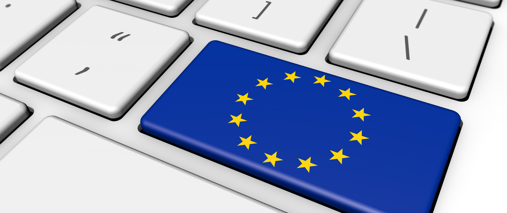 Biała klawiatura komputerowa - zbliżenie na klawisz "Enter". Na klawiszu flaga Unii Europejskiej.