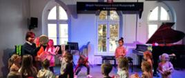 Grupa przedszkolaków na scenie gra na instrumentach perkusyjnych